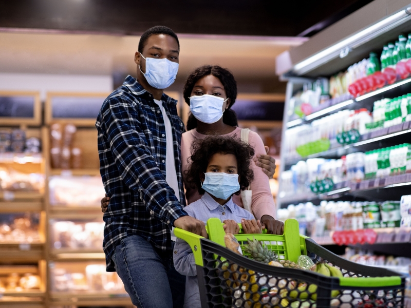 Black family shopping for groceries with masks on